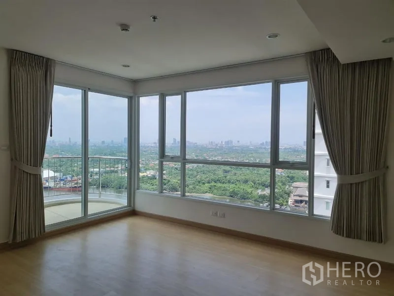 Condominium for sale in Yan Nawa, Bangkok - Corner living space with wraparound windows delivering sweeping greenery and river views.