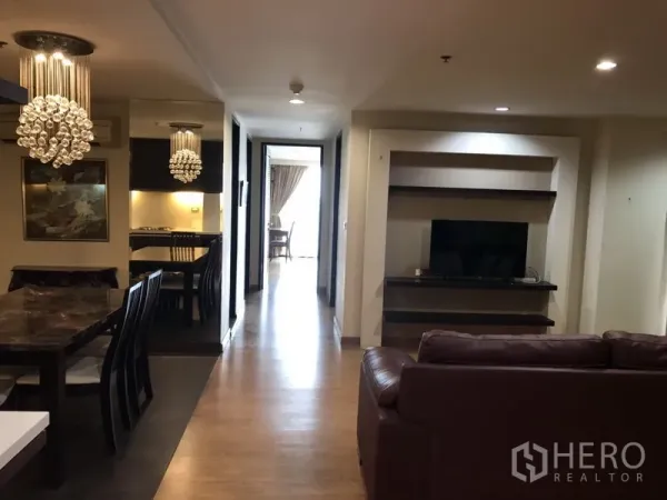 คอนโด ให้เช่าในWatthana, Bangkok - พื้นที่นั่งเล่นและรับประทานอาหารแบบเปิดโล่ง พื้นไม้ โคมระย้า และชั้นวางทีวีบิวท์อินตามแนวโถงทางเดินสว่าง