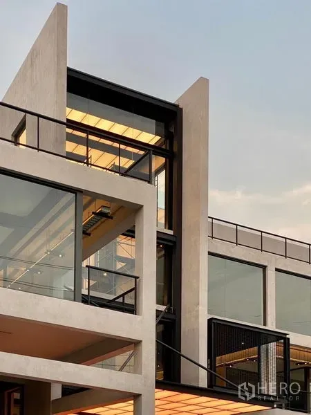 零售空间 出租 - 曼谷 Bang Na 区现代多层零售建筑外立面，玻璃幕墙与硬朗混凝土线条。