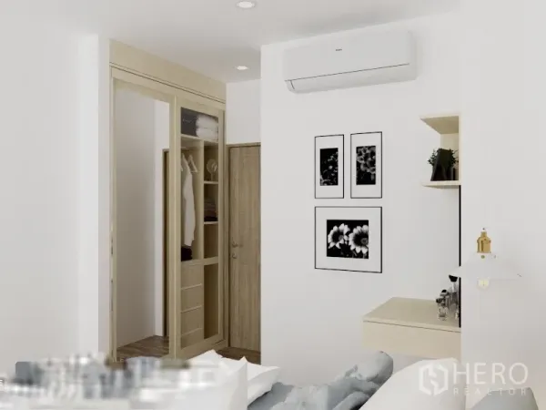 Condominium for rent or sale in Watthana, Bangkok - Bedroom closet area with sliding wardrobe doors, air conditioner, small desk, and black-and-white wall art.