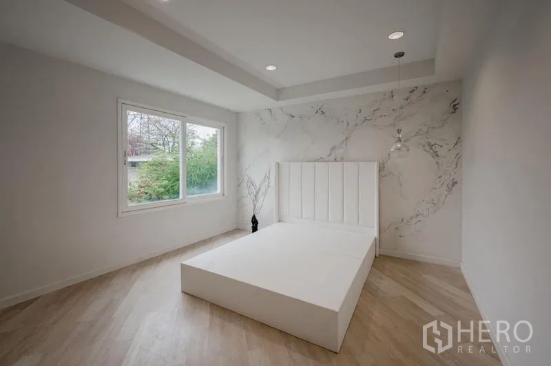 ทาวน์เฮาส์ ขาย - ห้องนอนสว่าง พื้นไม้โทนอ่อน หน้าต่างบานใหญ่ และเตียงแพลตฟอร์มสีขาว