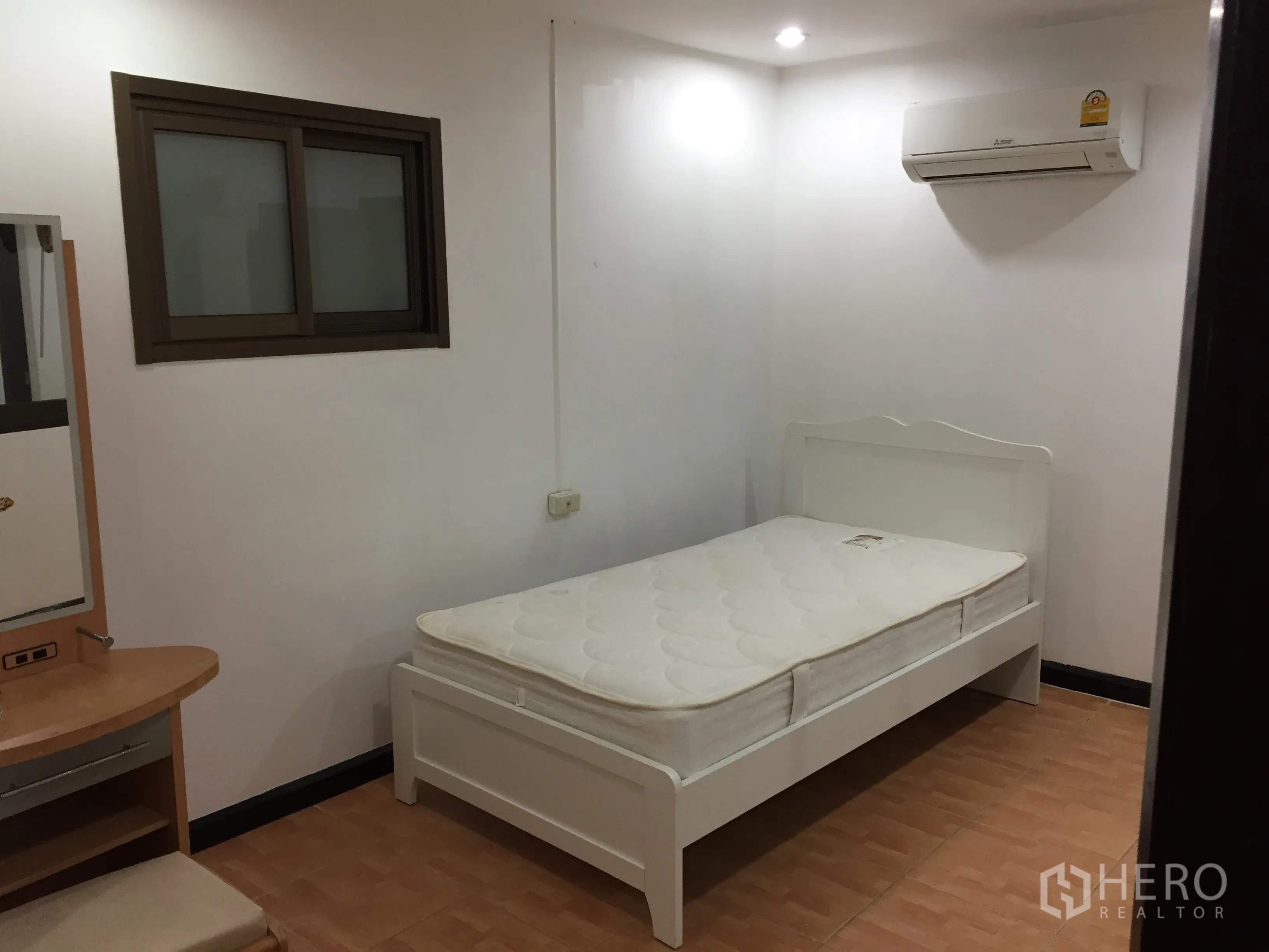 Condominium for rent in Watthana, Bangkok - Compact bedroom with single bed, air conditioner, and vanity desk.