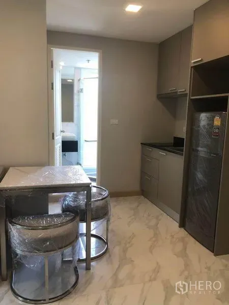 คอนโด for ในWatthana, Bangkok - ครัวแพนทรีพร้อมมุมทานข้าว ตู้สีเทา เก้าอี้สองตัว และพื้นลายหินอ่อนในคอนโดกรุงเทพฯ