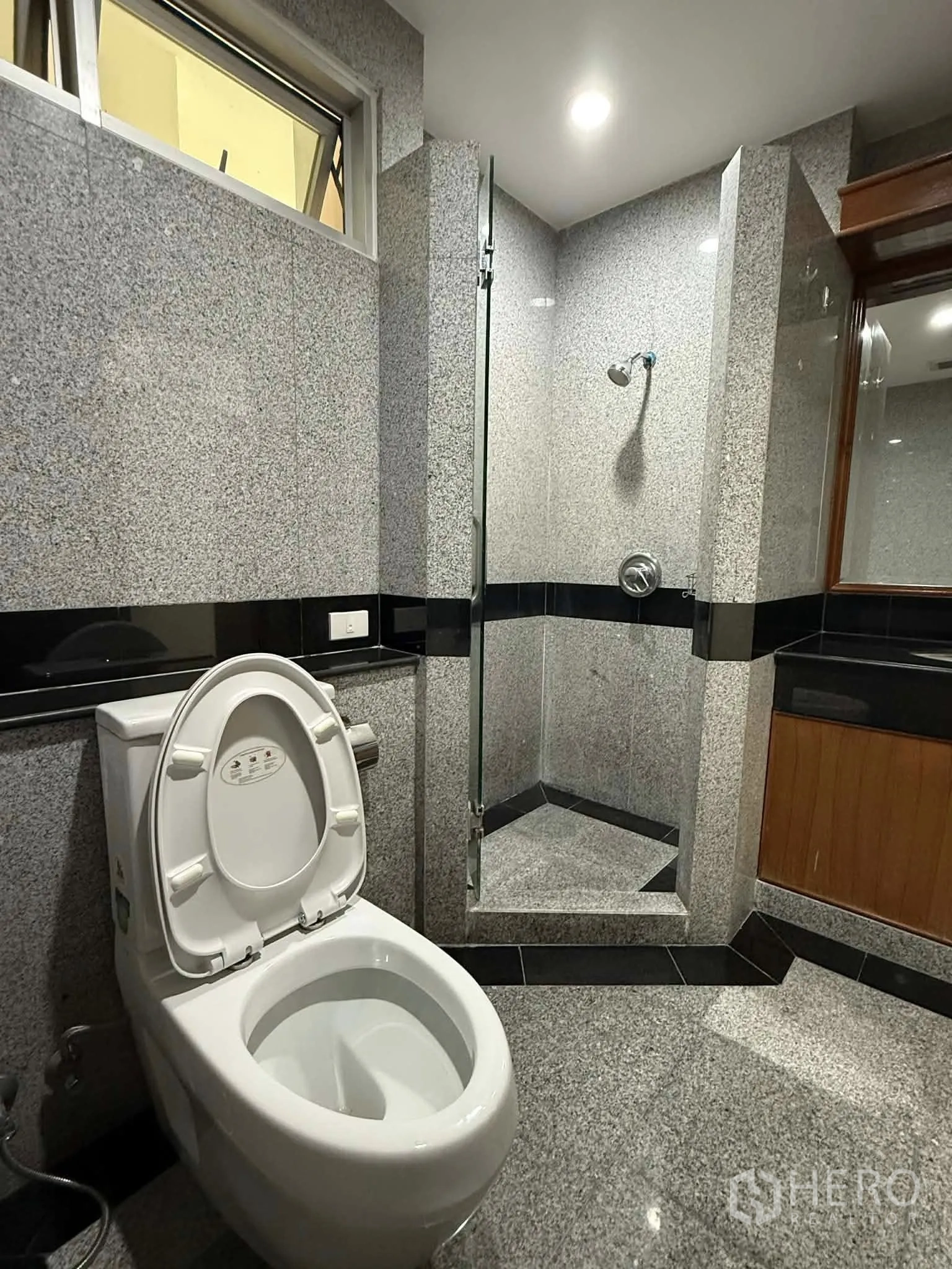 公寓 for rent in Pathum Wan, Bangkok - 浴室带玻璃淋浴间、坐便器与洗手台。