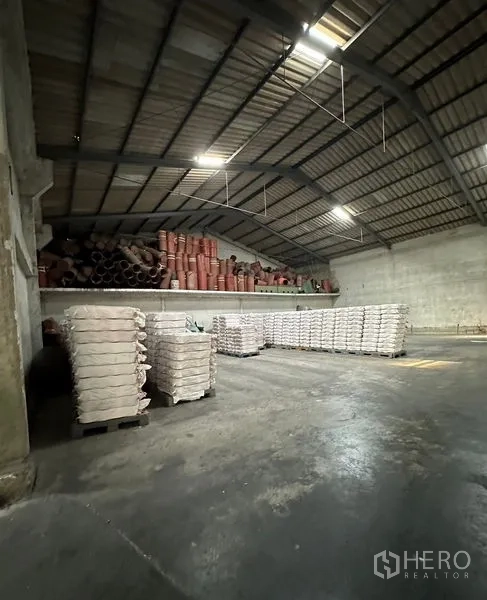 Warehouse for rent in Lat Krabang, Bangkok - Curved steel roof warehouse interior with pallet stacks on a clean concrete floor.