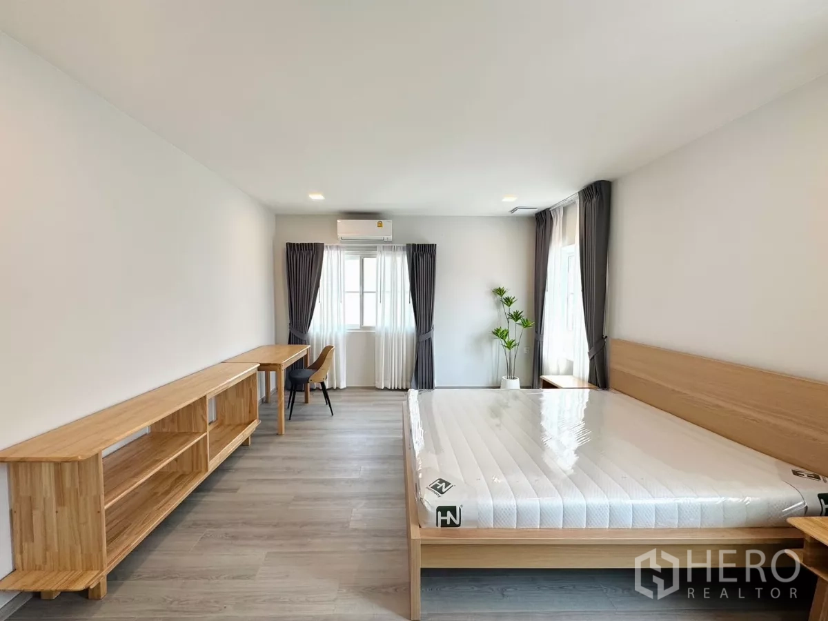 Detached House for rent in Bang Phli, Samut Prakan - Master suite angle with study desk, potted plant and corner windows.