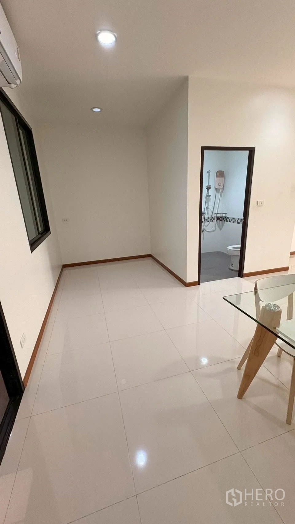 联排别墅 for rent in Phra Khanong, Bangkok - 明亮过道，亮面瓷砖地面、筒灯照明，通往浴室的门。