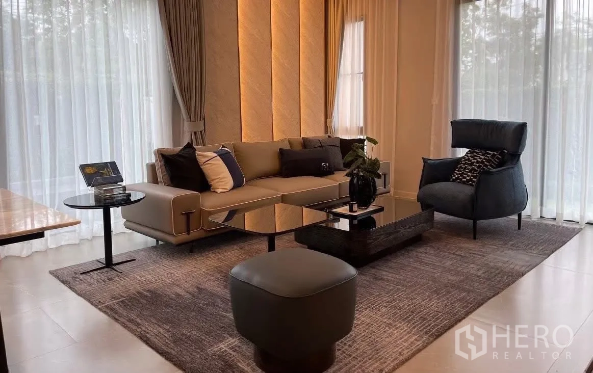 Detached House for rent in Bang Phli, Samut Prakan - Living room with sofa, armchair, glass tables, and sheer curtains.