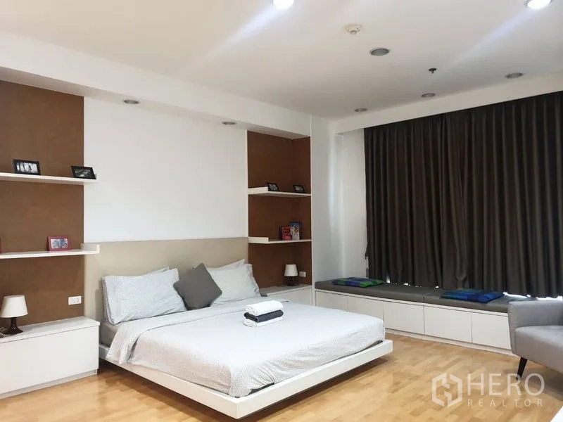 คอนโด ให้เช่าในKhlong Toei, Bangkok - ห้องนอนใหญ่หันสู่หน้าต่างบานกว้าง มีตู้วางทีวีและเก้าอี้เอน