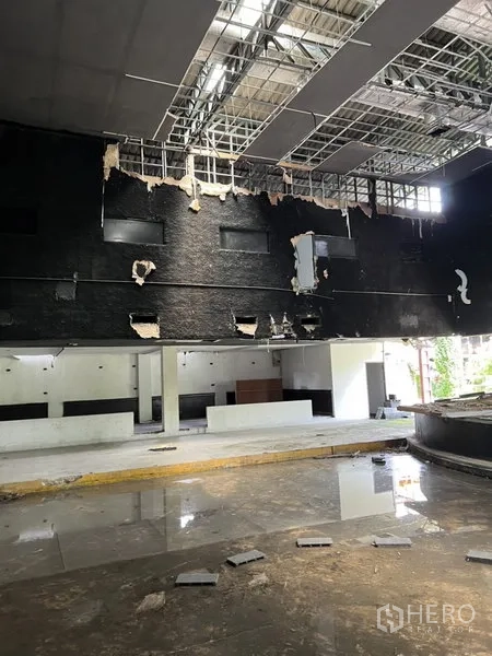 货栈 出租在Bang Kapi, Bangkok - 高挑室内，露出吊顶网格与服务台，自然采光良好。