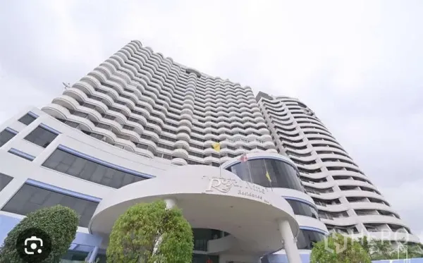 Condominium for sale in Huai Khwang, Bangkok - Curved high-rise facade of Royal Nine Residence with entrance canopy and balconies.