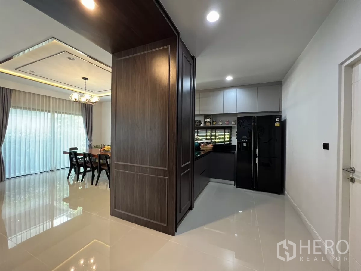 Detached House for rent or sale in Bang Kapi, Bangkok - Hallway linking dining area to modern kitchen with tall cabinetry.
