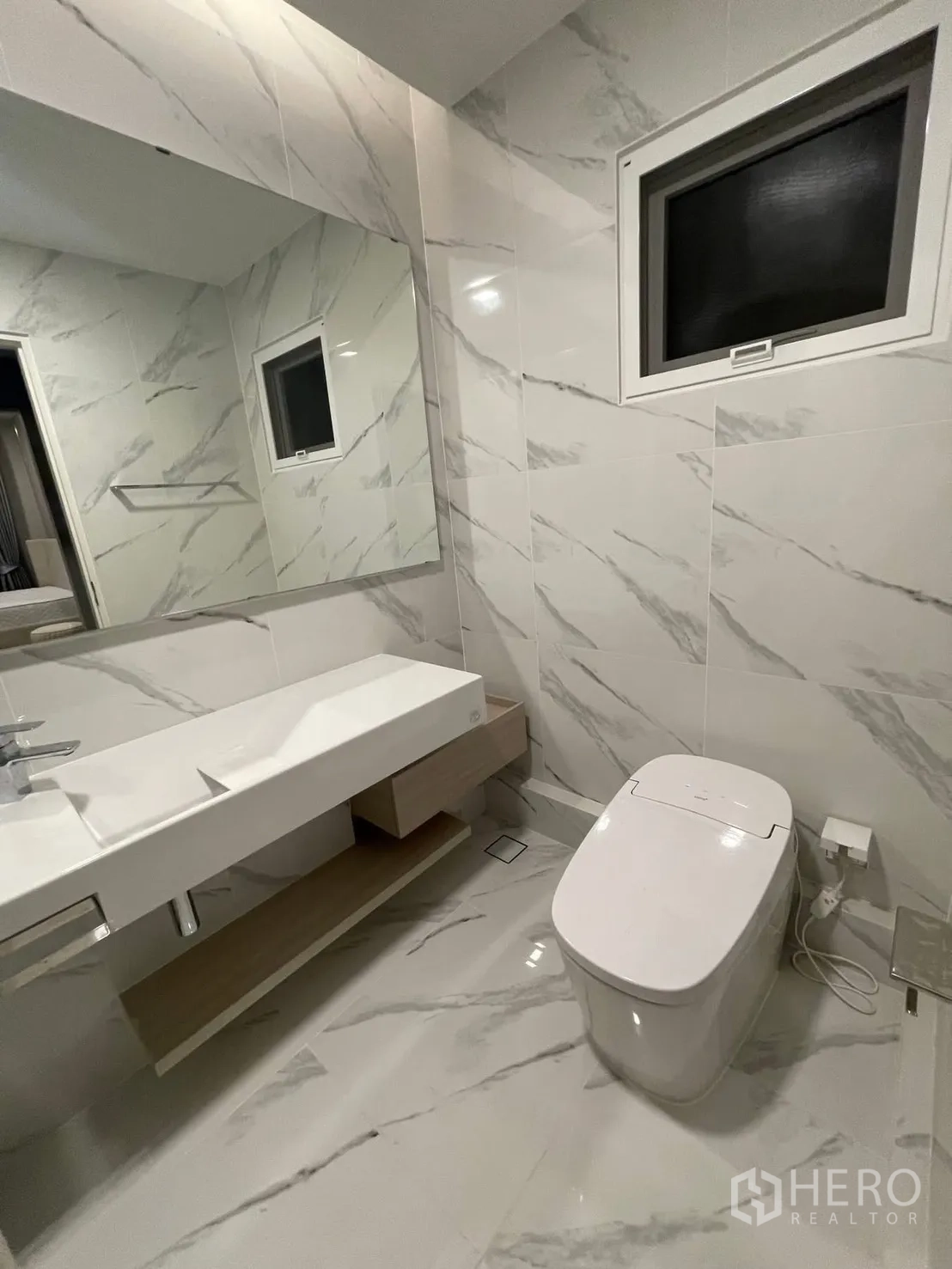 Detached House for rent in Prawet, Bangkok - Bathroom with marble-look tiles, wide vanity, and modern toilet.