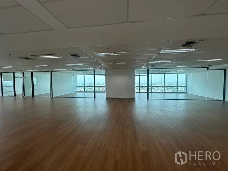 Office Space for rent - Open-plan office with wood flooring, grid ceiling lights, glass-partitioned rooms and skyline views.