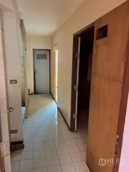 อาคารพาณิชย์ ให้เช่าในWatthana, Bangkok - โถงทางเดินปูพื้นกระเบื้องสีขาว มีประตูไม้หลายบานภายในอาคารพาณิชย์เก่า