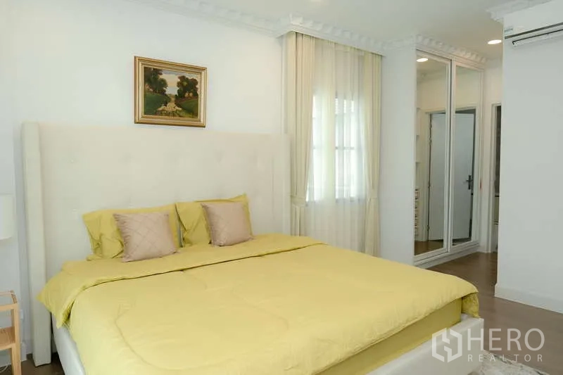 บ้าน ให้เช่าหรือขายในSaphan Sung, Bangkok - ห้องนอนชุดเครื่องนอนสีเหลือง ตู้เสื้อผ้าบานกระจก และแสงไฟนุ่มนวล