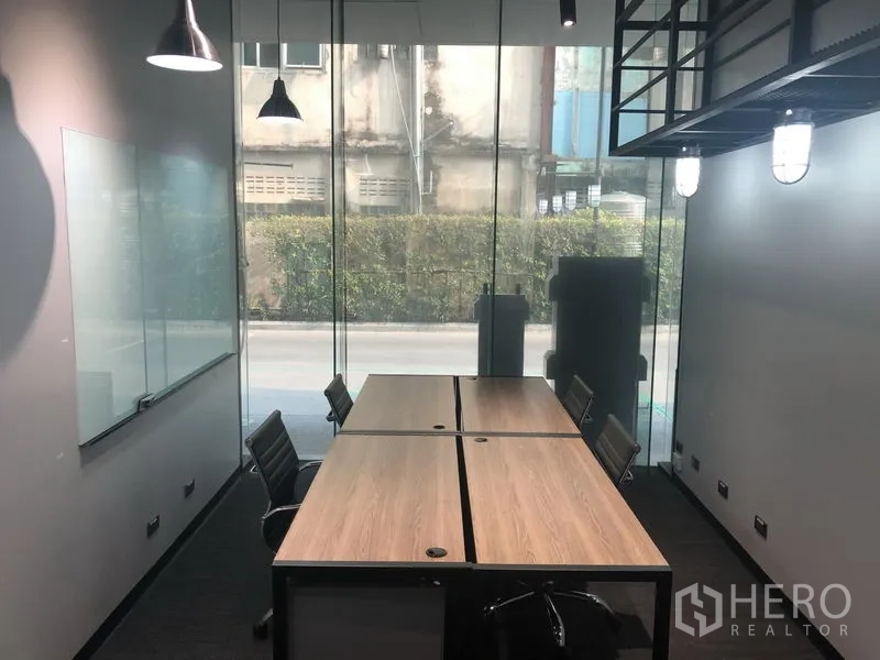 สำนักงาน ให้เช่าในKhlong Toei, Bangkok - ออฟฟิศพร้อมประชุม ผนังกระจกเต็มสูง มีกระดานไวท์บอร์ด โต๊ะต่อกันสองชุดและเก้าอี้ทำงาน