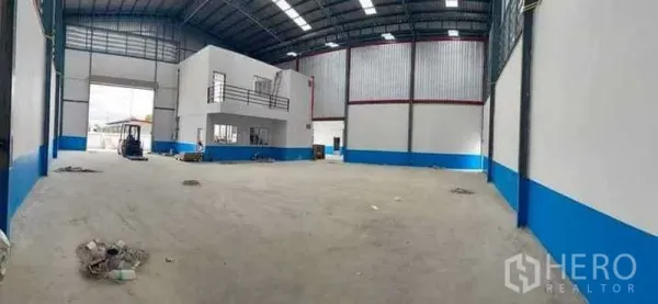 Warehouse for rent in Bang Phli, Samut Prakan - Spacious warehouse hall with high ceiling, skylights and a wide roller shutter entrance.