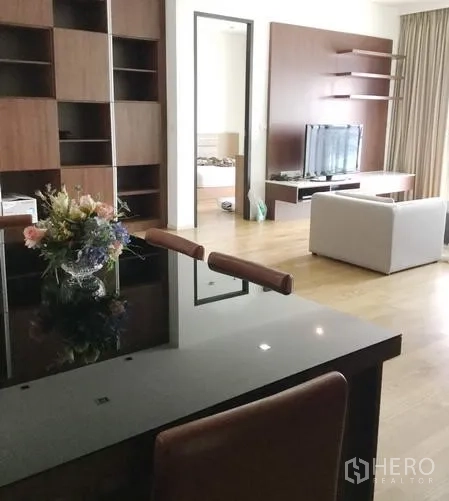 คอนโด ให้เช่าในWatthana, Bangkok - โซนทานอาหารคอนโดในกรุงเทพฯ โต๊ะกระจกสีดำ เก้าอี้หนัง พื้นไม้ และตู้บิวท์อินเชื่อมต่อสู่ห้องนั่งเล่น