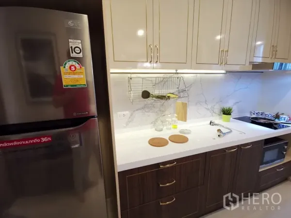 คอนโด ให้เช่าในPathum Wan, Bangkok - เคาน์เตอร์ครัวสมัยใหม่ ผนังลายหินอ่อน ตู้แขวน และตู้เย็นสแตนเลส