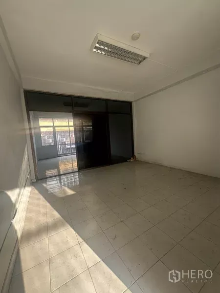 อาคารพาณิชย์ ให้เช่าในKhlong Toei, Bangkok - ห้องปูพื้นกระเบื้องกั้นกระจกสีเข้มและไฟฟลูออเรสเซนต์.