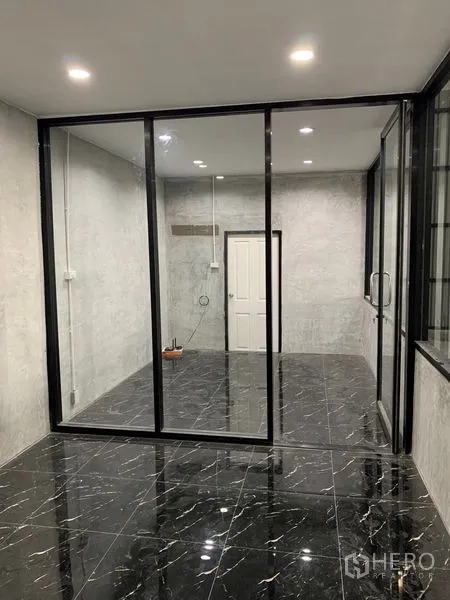 货栈 出租在Khan Na Yao, Bangkok - 仓库内的玻璃隔断办公室，黑色大理石纹地砖与嵌灯天花。