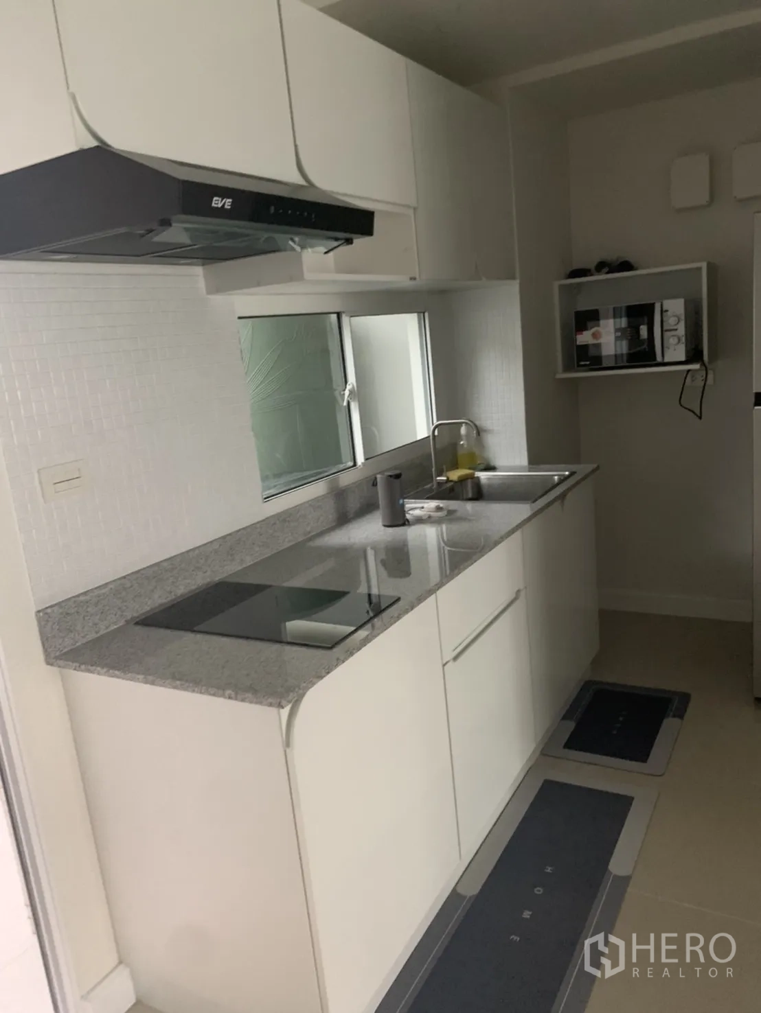 联排别墅 for rent in Bang Kapi, Bangkok - 现代厨房配花岗岩台面、水槽、电磁灶与抽油烟机。