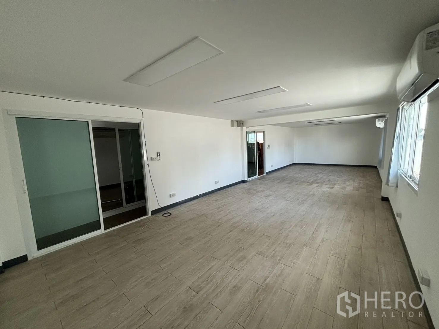 Office Space for rent in Watthana, Bangkok - Spacious office area with sliding glass door and multiple windows.