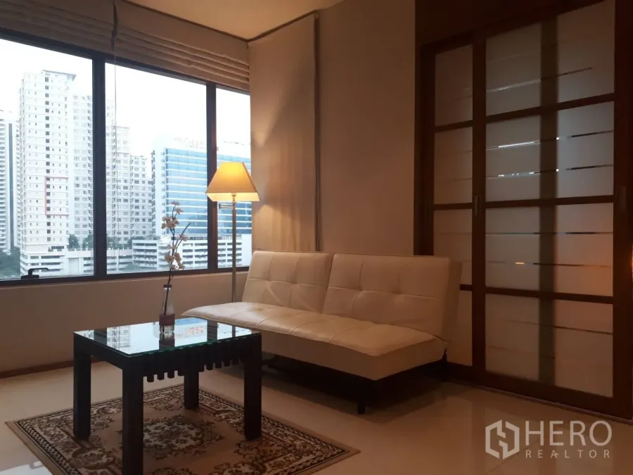 公寓 出租或出售在Khlong Toei, Bangkok - 采光充足的客厅，落地窗城市景观，白色沙发与玻璃茶几。