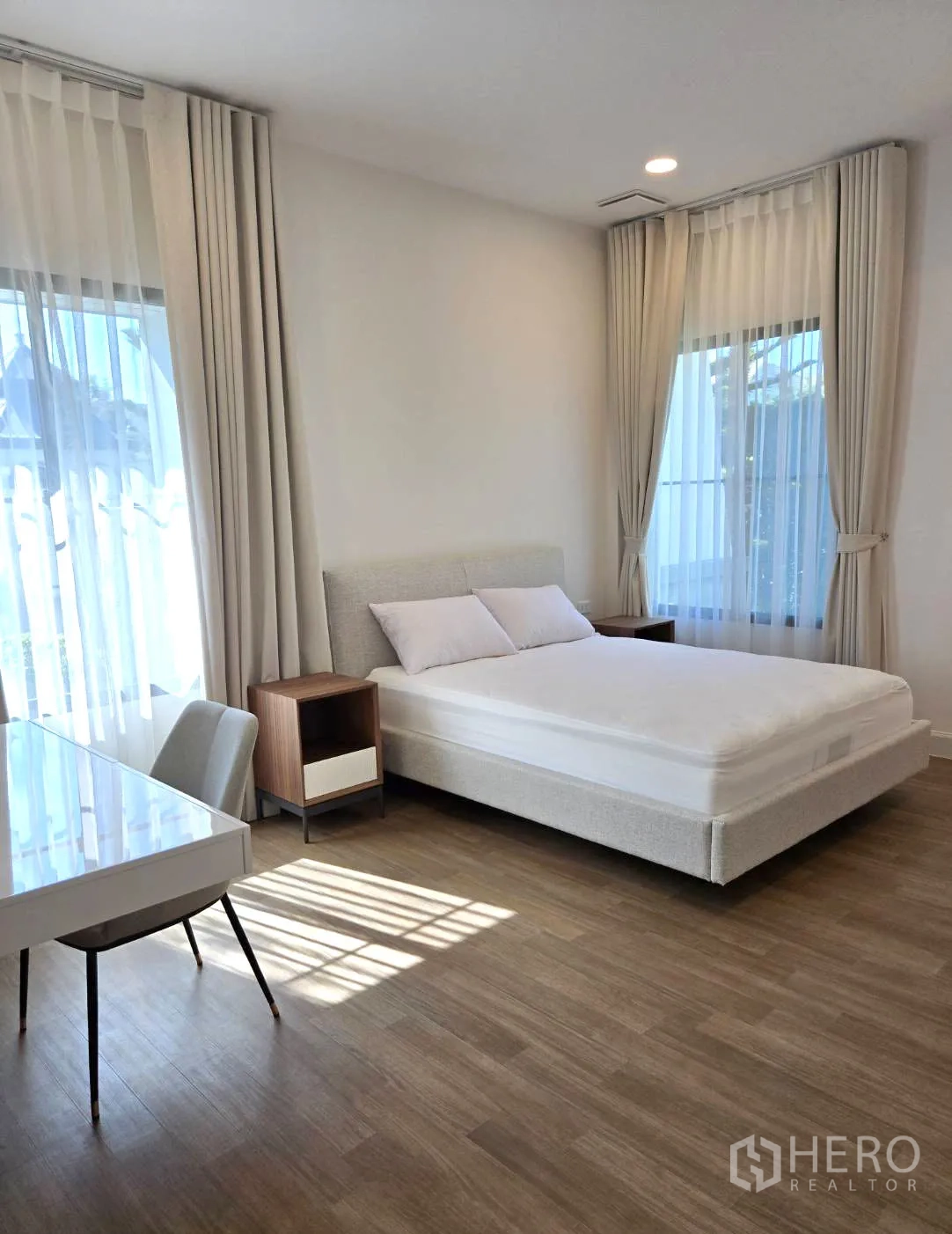 Detached House for rent in Saphan Sung, Bangkok - Sunlit bedroom with double bed, desk and light curtains.