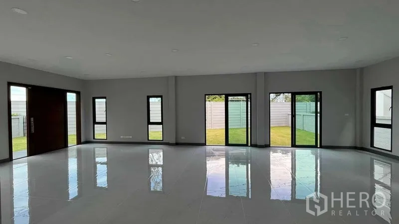 Detached House for sale in Bang Phli, Samut Prakan - Wide living area with several sliding doors and outlook to the green yard.