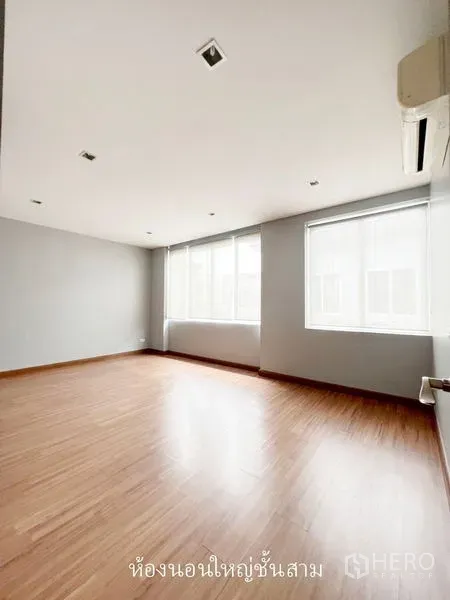 Townhouse for rent or sale in Don Mueang, Bangkok - Large sunlit bedroom with wood floors, air conditioner and wide windows.