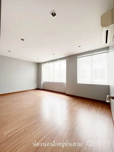 Townhouse for rent or sale in Don Mueang, Bangkok - Large sunlit bedroom with wood floors, air conditioner and wide windows.