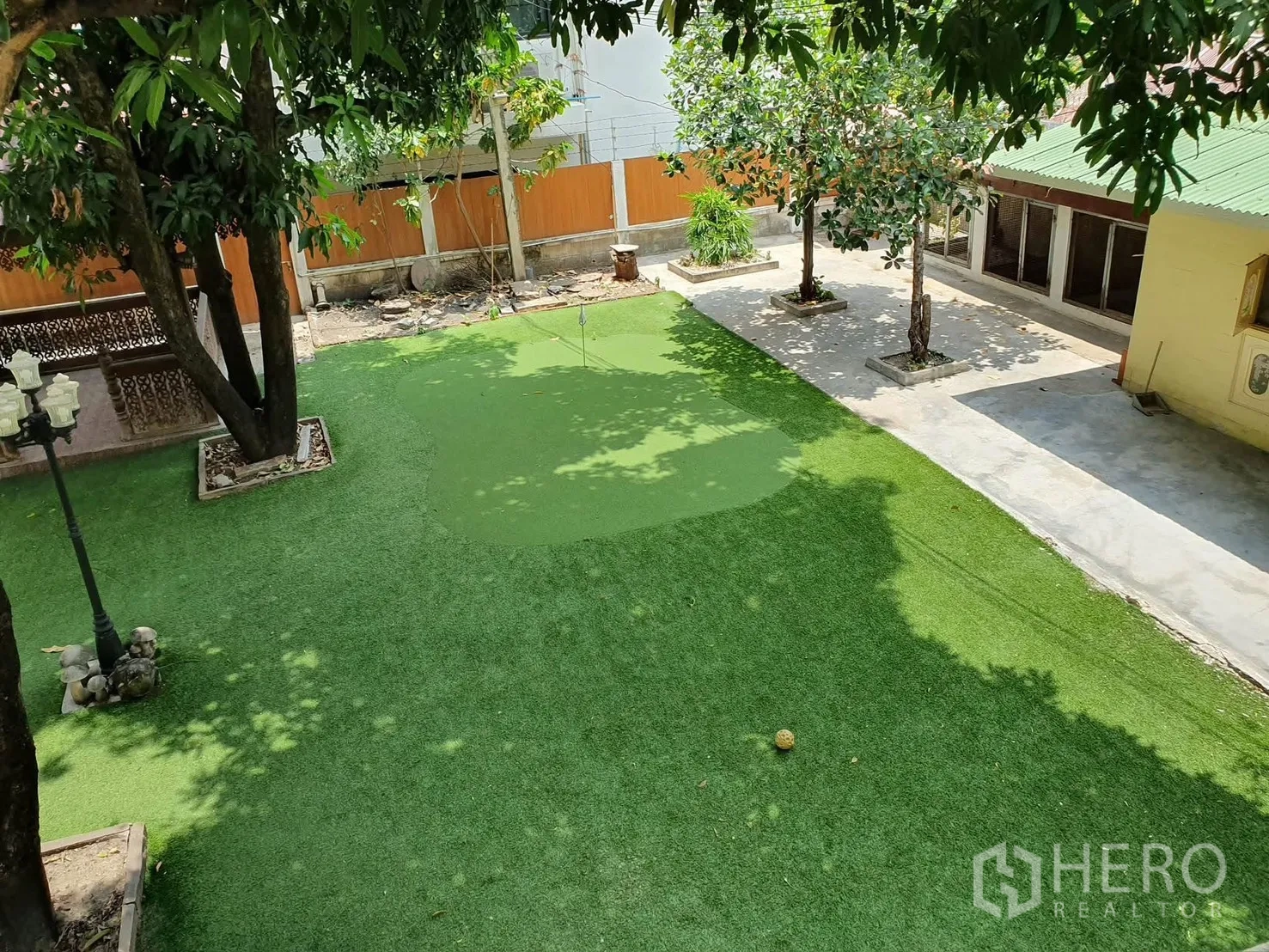 Detached House for rent in Sathon, Bangkok - Spacious garden with manicured lawn, mature trees, and a paved patio beside a single-storey annex.