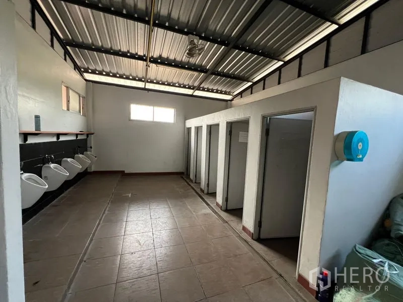 Warehouse for rent in Saphan Sung, Bangkok - Warehouse restrooms with multiple stalls, urinals and tiled floor.