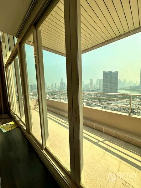 คอนโด ให้เช่าหรือขาย - ประตูกระจกบานเลื่อนเปิดสู่ระเบียงยาวชมวิวเมือง