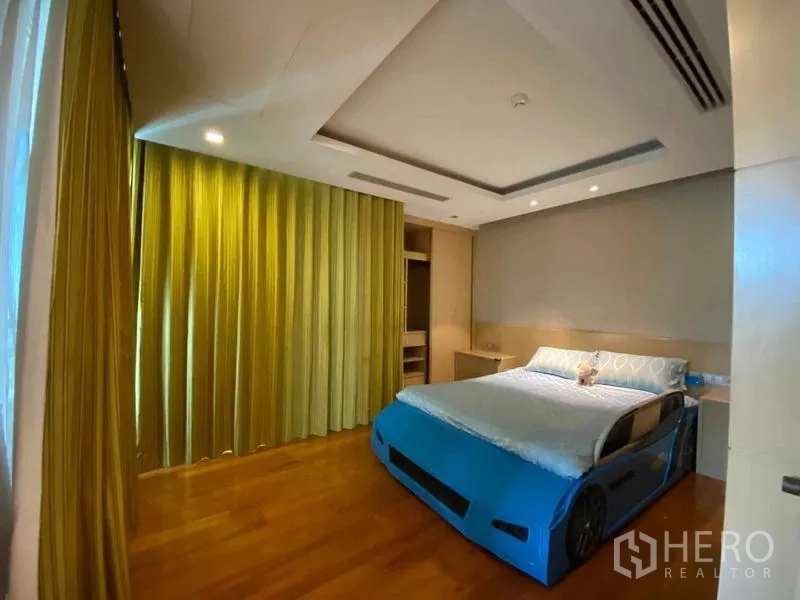 คอนโด ให้เช่าในKhlong Toei, Bangkok - ห้องนอนอบอุ่น ผ้าม่านสีเขียว และเตียงลายรถสีน้ำเงิน