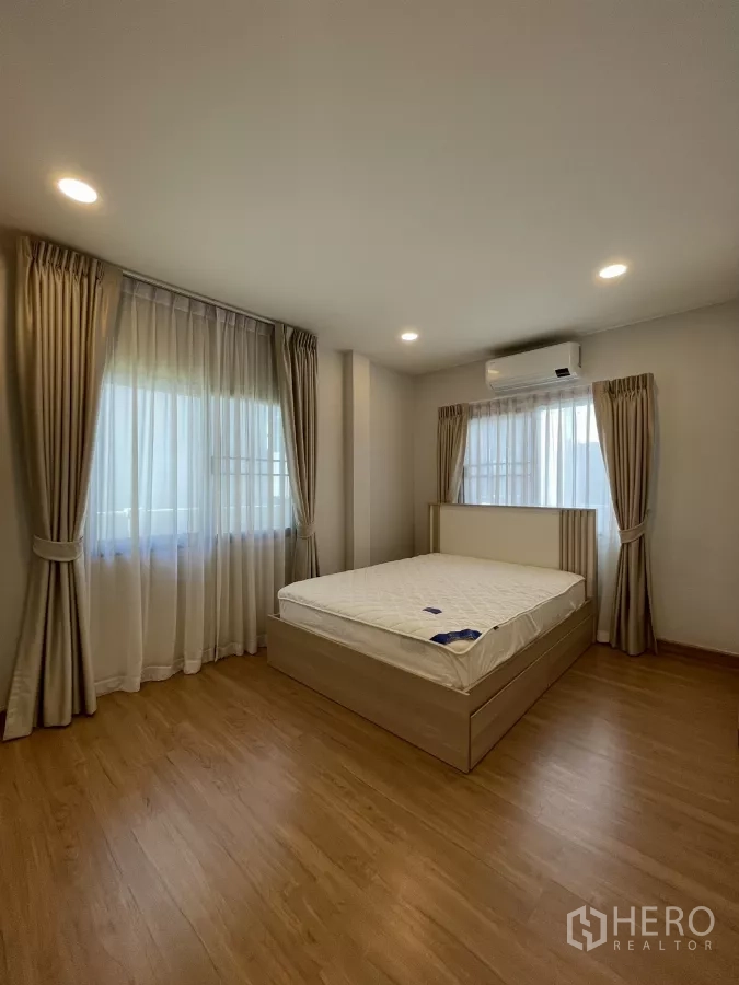 Detached House for rent in Bang Phli, Samut Prakan - Fourth bedroom with wood-tone bed, warm curtains and AC.