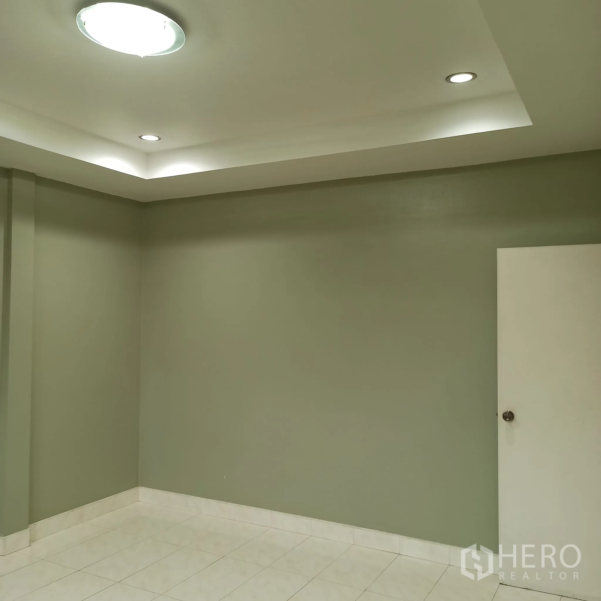 Townhouse for rent in Wang Thonglang, Bangkok - Empty room with recessed ceiling and pale green walls.