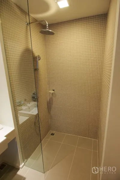 คอนโด ให้เช่าในPathum Wan, Bangkok - ห้องน้ำทันสมัย มีฉากกั้นกระจกและฝักบัวเรนชาวเวอร์ กระเบื้องโมเสกสีเบจ