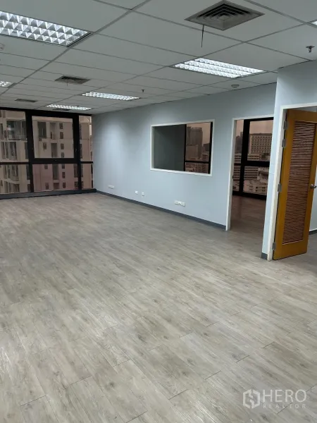 办公空间 出租在Khlong Toei, Bangkok - 宽敞开放式办公室，木纹地板，分隔窗与大幅城市景观窗，格栅天花灯光。