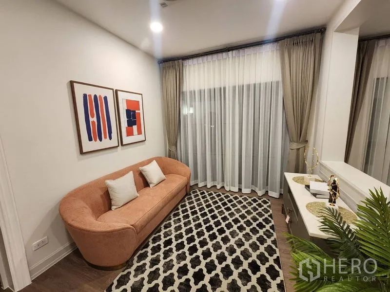 Detached House for rent or sale - Compact sitting area with peach sofa, patterned rug and floor-to-ceiling sheer drapes