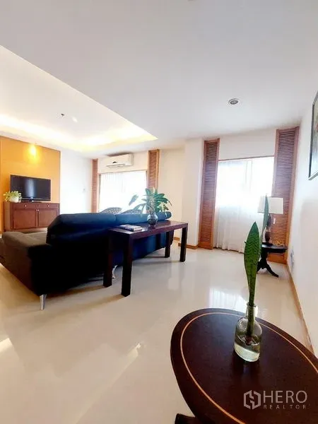 อพาร์ทเมนท์ ให้เช่า - ห้องนั่งเล่นสว่าง มีโซฟาตัวแอล โต๊ะทำงาน ตู้ทีวี และฝ้าเพดานซ่อนไฟ