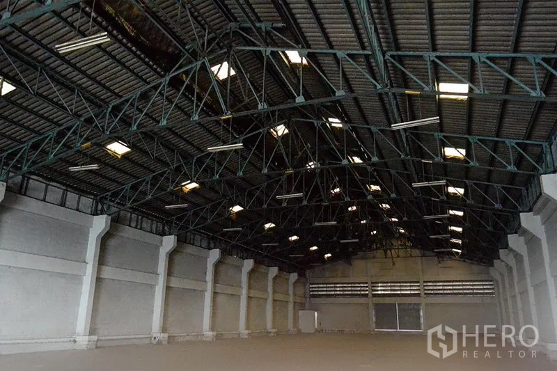 货栈 出租在Prawet, Bangkok - 仓库内部高钢结构屋顶，带天窗与平整混凝土地面。