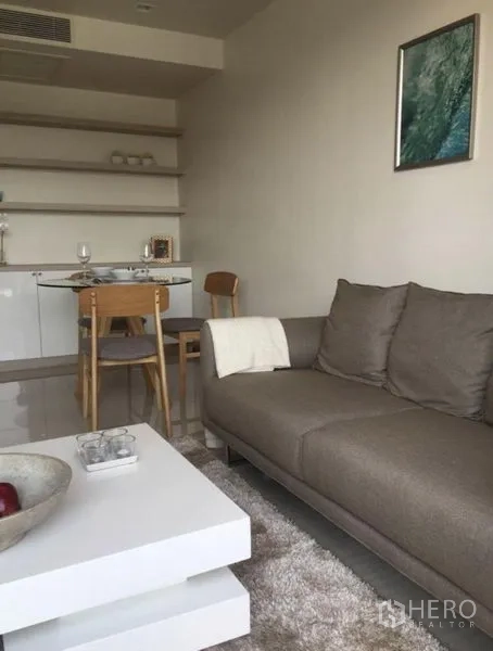 คอนโด ให้เช่าหรือขายในWatthana, Bangkok - มุมนั่งเล่นอบอุ่น โซฟาสีเทา โต๊ะกลางสีขาว และชุดโต๊ะอาหารพร้อมชั้นวาง