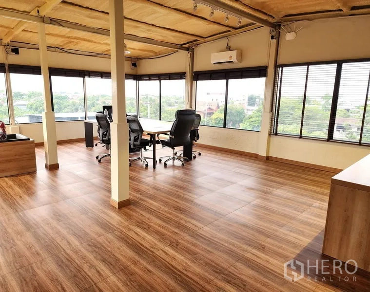 Warehouse for rent in Bang Kruai, Nonthaburi - Corner office with wood-look flooring, panoramic windows and a meeting table.