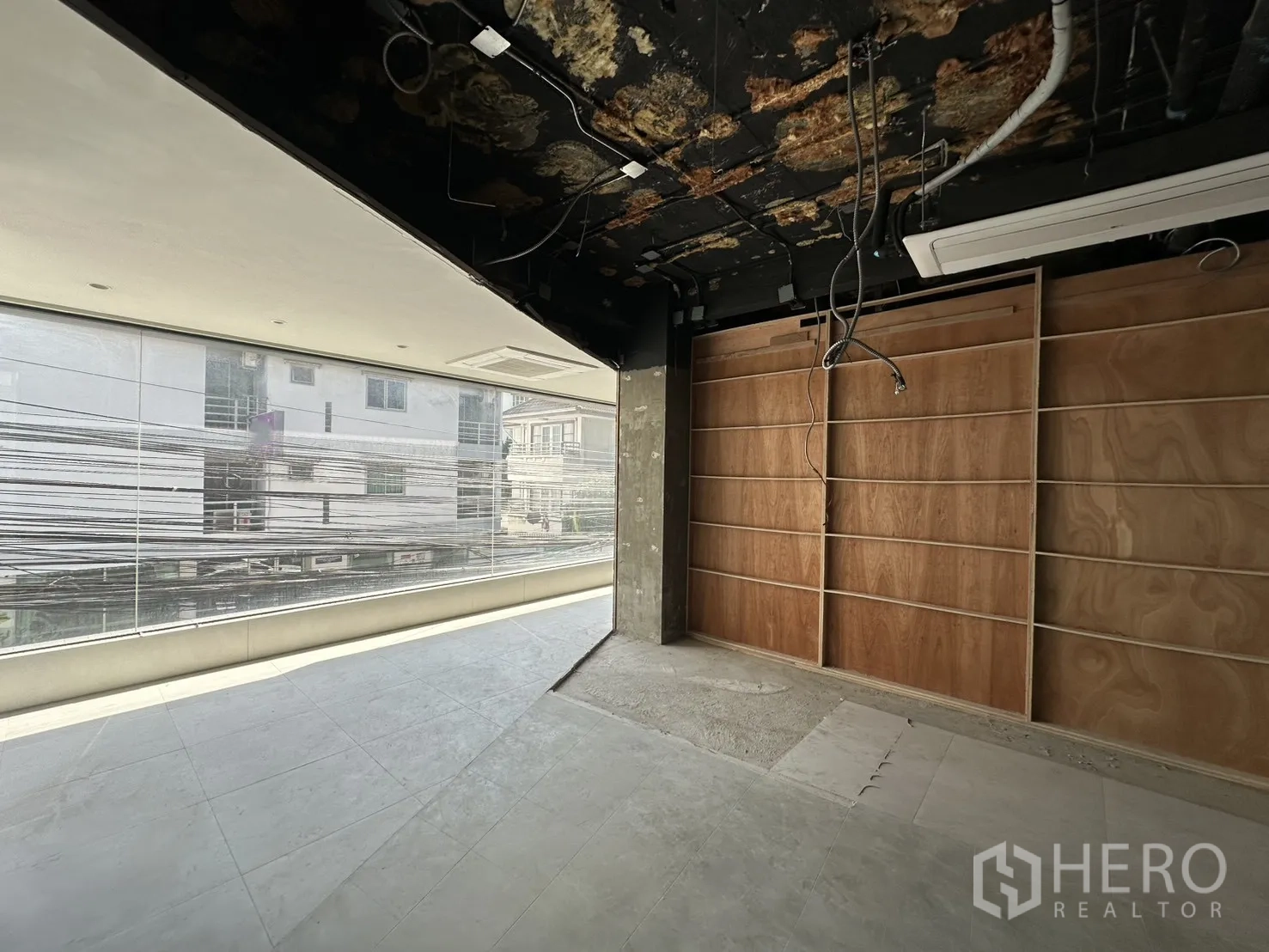 Retail Space for rent in Watthana, Bangkok - Corner zone with panoramic street-facing window and plywood shelving wall.