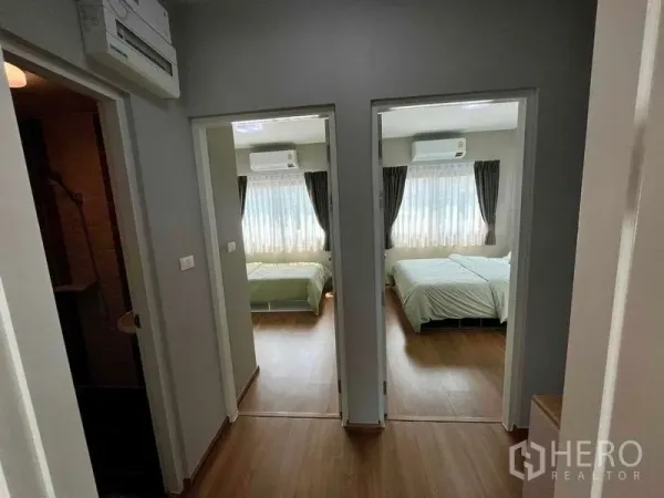 Townhouse for sale in Sai Mai, Bangkok - Upstairs landing with wooden floor leading to two air‑conditioned bedrooms.