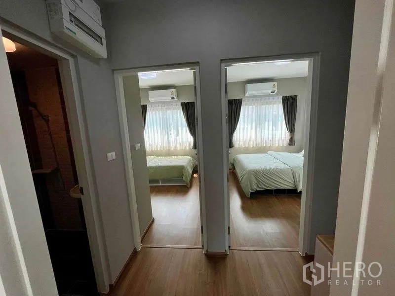 Townhouse for sale in Sai Mai, Bangkok - Upstairs landing with wooden floor leading to two air‑conditioned bedrooms.