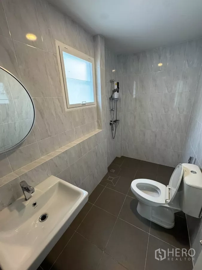 Detached House for rent or sale in Bang Bo, Samut Prakan - Bathroom with gray tiles, shower, and white sanitary ware with window.